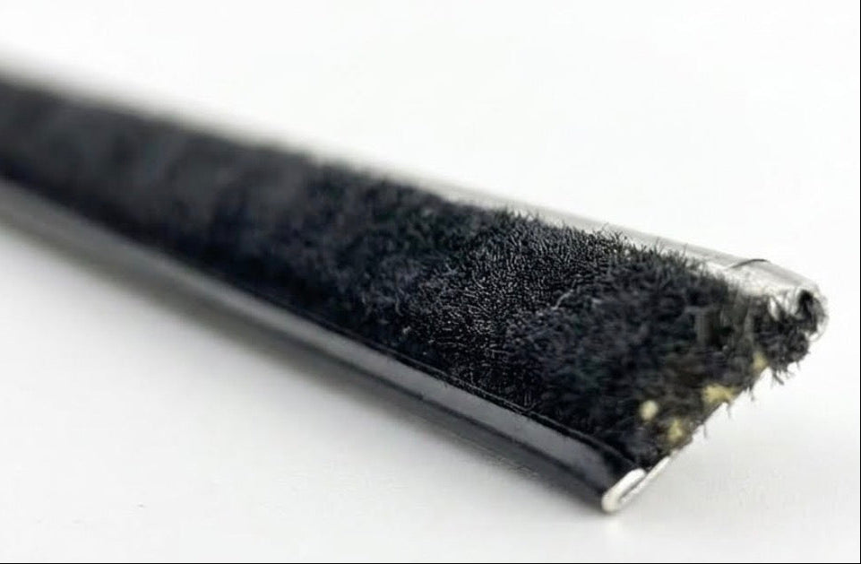 Close-up of a straight belt line window sweep showing the black fuzzy pile and cut end.
